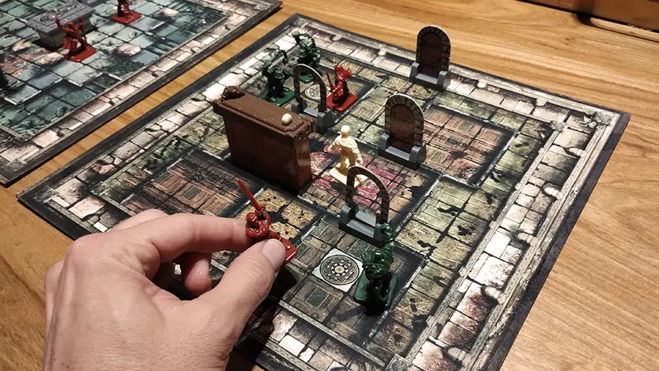 Jugador moviendo una miniatura sobre mapa de aventura impreso